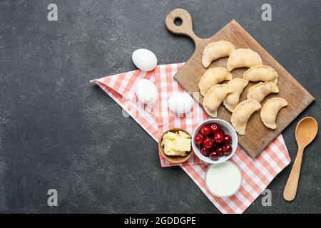 Composizione con gnocchi di ciliegio crudo su sfondo scuro Foto Stock