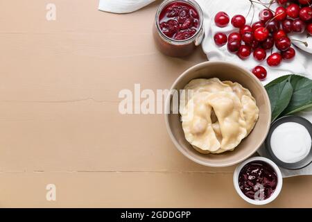 Composizione con gustosi gnocchi di ciliegia su sfondo colorato Foto Stock