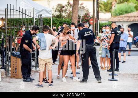 Le guardie di sicurezza all'ingresso del Jardins de Terramar Festival verificano che le persone entrino nel locale con maschere facciali a causa delle misure di sicurezza del Covid-19 e senza cibo o bevande a causa delle norme anti-Covid-19. Il gruppo indie pop spagnolo la Casa Azul si esibisce davanti a un migliaio di persone sedute in sedie e indossando maschere protettive obbligatorie a causa delle misure di sicurezza del Covid-19 al Jardins de Terramar Festival di Sitges (Barcellona) la Casa Azul è un gruppo musicale con varie tendenze musicali come Indie Pop, Musica elettronica, Funk, Europop e Synthpop e cantano con caschi simulat Foto Stock