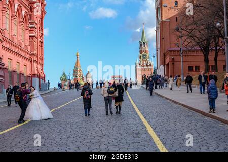 Una vista delle persone che camminano sullo sfondo della Torre del Cremlino, la Cattedrale di Pokrovsky e il Mausoleo Lenin sulla Piazza Rossa a Mosca, Russia Foto Stock