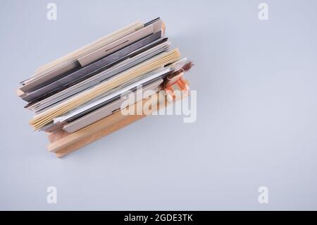 Vista dall'alto dei documenti riempiti su un ripiano di legno isolato su sfondo grigio chiaro Foto Stock