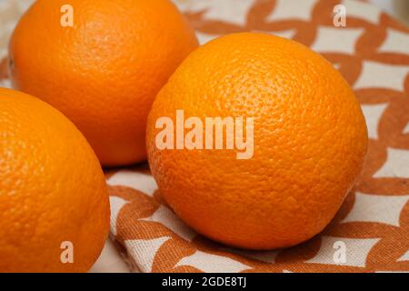 Primo piano tre frutta arance intere su sfondo di legno. Foto Stock