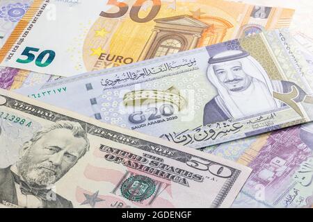 Primo piano 20 Riyal dell'Arabia Saudita con banconote da 50 dollari USA a 50 euro. Venti banconote Riyal del paese arabo. Denaro degli Stati Uniti e dell'Europa Foto Stock