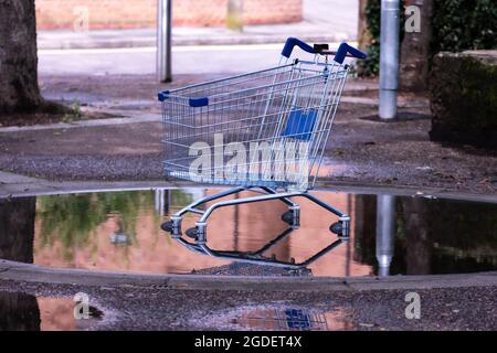 Carrello rubato sulla strada, abbandonato carrello in una pagaia Foto Stock