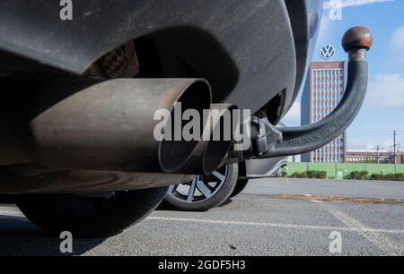 Wolfsburg, Germania. 11 Agosto 2021. Tubi di scarico di una Volkswagen, fotografati con il grattacielo di marca presso lo stabilimento VW Wolfsburg. Credit: Julian Stratenschulte/dpa/Alamy Live News Foto Stock