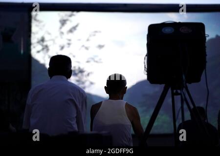 (210813) -- TAIYUAN, 13 agosto 2021 (Xinhua) -- Villagers vedere un film all'aperto nel villaggio di Gaojiayan, Sanjiao Township della contea di Liulin, provincia di Shanxi della Cina del nord, 10 agosto 2021. Nel 1975, Sanjiao Township fondò un team di proiezione cinematografica. Liu Bufei e Liu Dengzhao, entrambi cinefili fin dall'infanzia, si unirono alla squadra e divennero proiettisti rurali. Nel 2007, la squadra divenne una troika con l'ingresso del proiettile di seconda generazione Xue Xiaogang, che aveva visto film all'aperto nel villaggio mentre era cresciuto. Nel corso degli anni, il team di proiezione, per innumerevoli volte ha guidato lungo la c Foto Stock