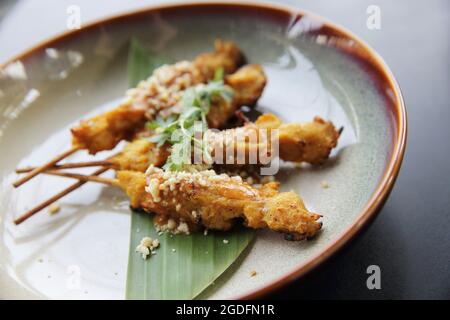 satay di pollo, ayam di sate e lontong con salsa di arachidi Foto Stock