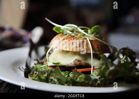 bagel con bistecca e formaggio su fondo di legno Foto Stock