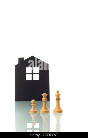 Fotografia concettuale di due pezzi di scacchi bianchi (re e regina) che rappresentano metaforicamente una coppia eterosessuale bianca con un bambino, con il silhou Foto Stock