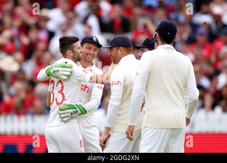 Mark Wood dell'Inghilterra (a sinistra) festeggia con il compagno di squadra Jos Buttler dopo che ha fatto una presa fuori del suo bowling per prendere il wicket del Pant indiano di Rishabh durante il giorno due della seconda partita di prova della cinch a Lord's, Londra. Data immagine: Venerdì 13 agosto 2021. Foto Stock