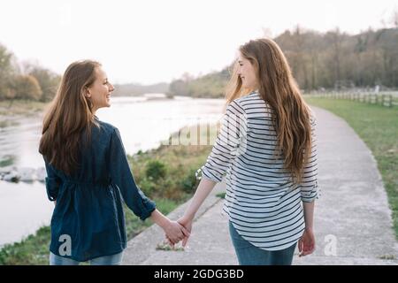 Fidanzate tenendo a piedi dal fiume, Belluno, Veneto, Italia Foto Stock