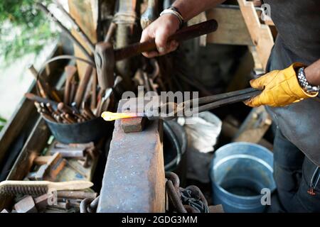 Fabbro lavora nella sua fucina Foto Stock