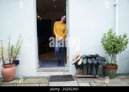 La donna nella porta accanto wellies Foto Stock