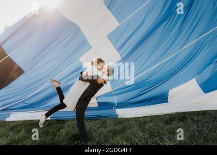 Appena fidanzati kissing, mongolfiera in background Foto Stock