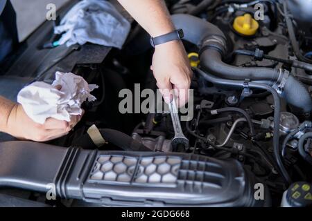 Meccanico automatico che lavora riparando un motore di automobile con un  sp. Aperto Foto stock - Alamy