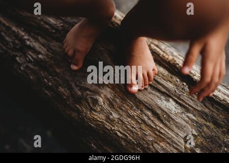 Primo piano di piedi a piedi nudi su pezzo di legno fuori dall'acqua Foto Stock