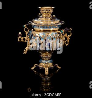 Samovar oro di lusso isolato su sfondo nero con riflessi. Souvenir con motivi tradizionali. Foto Stock