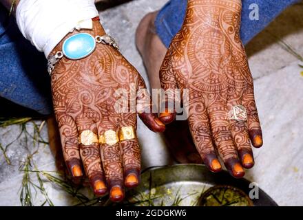 Bella illustrazione di Henna Mehndi sulle mani giuste dello sposo indiano, il colorante di Henna è applicato sulla mano dell'uomo durante il festival indiano del matrimonio Foto Stock