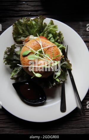 bagel con bistecca e formaggio su fondo di legno Foto Stock