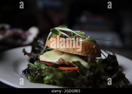 bagel con bistecca e formaggio su fondo di legno Foto Stock