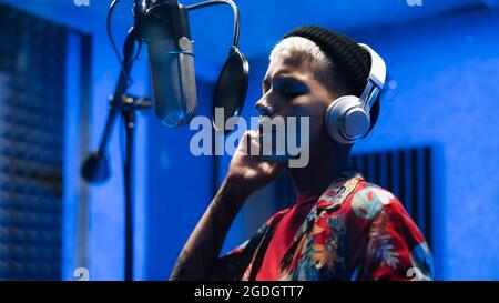 Giovane cantante che registra un nuovo album di canzoni all'interno dello studio di produzione musicale Foto Stock