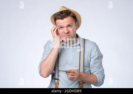 Il giovane uomo d'affari che tiene e conta le fatture del dollaro di soldi nelle mani Foto Stock