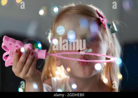 Un bambino soffia bolle, i bambini giocano con bolle di sapone Foto Stock