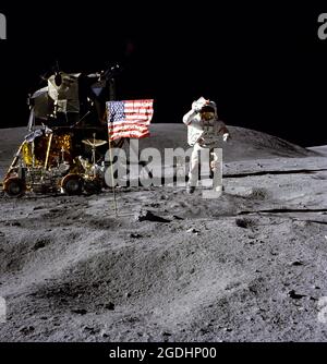 L'astronauta John W. Young, comandante della missione di atterraggio lunare Apollo 16, salta dalla superficie lunare.il modulo lunare (LM) 'Orion' è sulla sinistra. Il veicolo Lunar in movimento è parcheggiato accanto al LM. L'oggetto dietro Young all'ombra della LM è la telecamera/spettrografo a ultravioletti lontani. Foto Stock