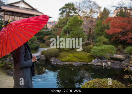 Donna ammirando il tradizionale giardino zen giapponese a Kyoto Foto Stock