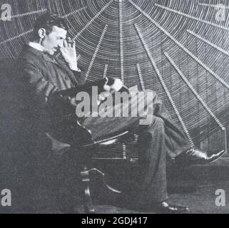 Nikola Tesla vicino alla bobina a spirale del suo trasformatore ad alta frequenza. Foto Stock