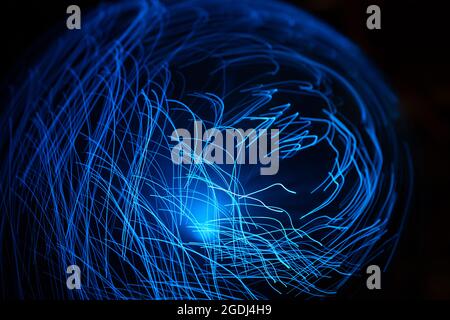 Particelle astratte blu e linee con bokeh e sfocatura su sfondo scuro. Foto Stock