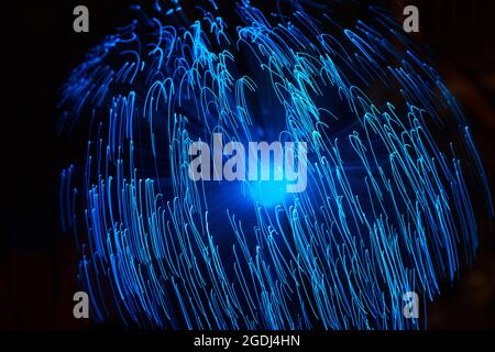 Particelle astratte blu e linee con bokeh e sfocatura su sfondo scuro. Foto Stock