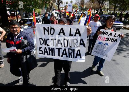 Cochabamba, Bolivia. 13 Agosto 2021. "Porre fine alla dittatura sanitaria", legge il cartello di un dimostratore durante un raduno tenuto in mezzo alla pandemia di Corona sotto lo slogan "protesta nazionale per la libertà, contro la bocca al naso e contro le vaccinazioni". Mentre la vaccinazione obbligatoria contro Corona è in corso di discussione, gli attivisti anti-vaccinazione in tutto il paese chiedono proteste contro presunti tentativi di ricerca da parte delle aziende farmaceutiche. Credit: David Flores/dpa/Alamy Live News Foto Stock