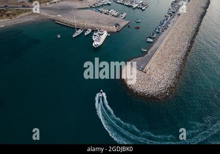 Vista aerea del motoscafo che entra negli yacht del porto ormeggiati presso il porto turistico. Porto di Latsi Paphos Cipro Foto Stock