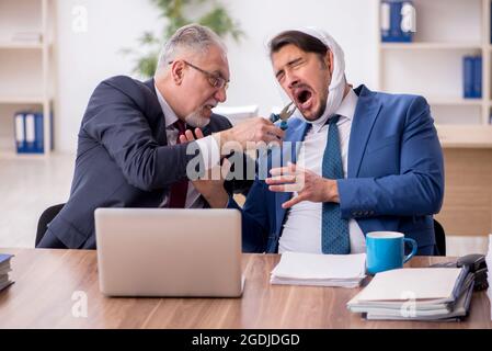 Giovane impiegato d'affari che soffre di mal di denti in ufficio Foto Stock