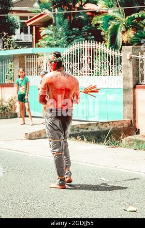 BATAA, FILIPPINE - 09 marzo 2018: Un colpo verticale di un uomo per strada durante la settimana Santa nelle Filippine Foto Stock