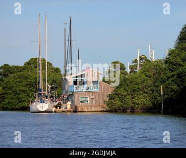 Barche a vela ormeggiate sul fiume vicino a una vecchia casa vicino Coco Beach, Florida Foto Stock