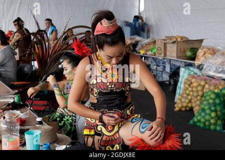 Città del Messico, Messico, 13 agosto 2021: Una donna indigena che dipinge la sua pelle, prima di partecipare a una danza pre-ispanica, come parte del 500 ° anniversario della resistenza indigena, e protesta contro lo sfollamento, lo sfruttamento e le denunce delle violazioni dei diritti umani degli indigeni. È commemorato 500 anni della caduta di Tenochtitlan, il luogo più sacro della civiltà azteca, nel centro di Città del Messico, per celebrare 500 anni dalla conquista spagnola della capitale azteca. Credit: Luis Barron / Eyepix Group / Alamy Live News Foto Stock