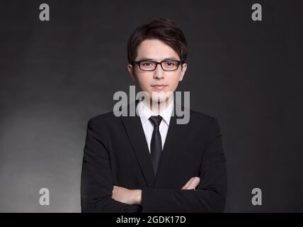Giovane bell'uomo in abito nero e con occhiali Foto Stock