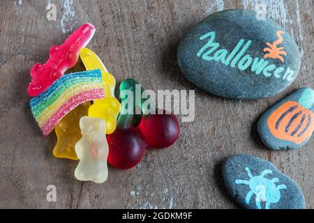 Sfondo in legno con pietre e treats dipinti di Halloween Foto Stock