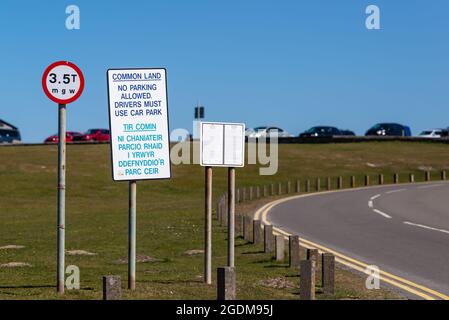 Cartello che impedisce alle auto di parcheggiare su un terreno comune, in inglese e gallese Foto Stock