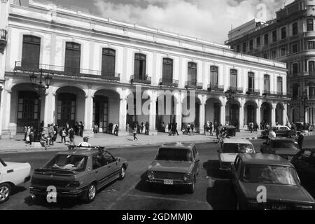 Entrata dell'hotel a l'Avana Cuba gente cammina archi ad arco parlanti auto balconi ringhiere metalliche storia in stile coloniale finestre di taxi vecchio stile Foto Stock