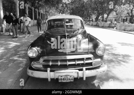 Auto americana a l'Avana Cuba persone che camminano per veicoli classici alberi camicia da tè in stile albero colonne coloniali pilastri pilastri pilastri colonne colonne colonne colonne colonne targa targa Foto Stock