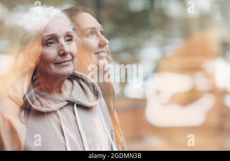 Nonna e nipote immagine a doppia esposizione. Ritratto di donna giovane e anziana. Amore, sogni e felice concetto di relazioni familiari Foto Stock