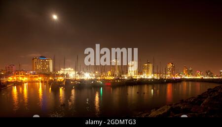 Israele, Tel Aviv skyline e yacht marina di notte come visto da ovest Foto Stock