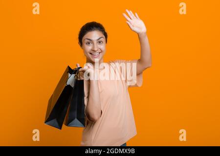 La donna indiana tiene i sacchetti di shopping che ondolano la mano. Vendita e Black Friday Concept Foto Stock