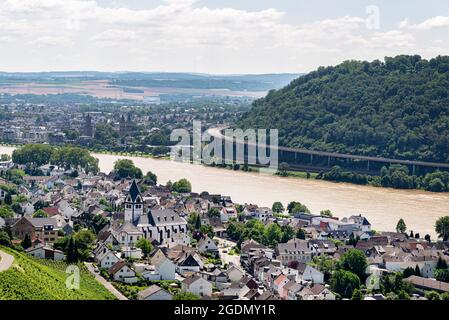 Il fiume Reno scorre tra il villaggio e la foresta colline coperte lungo la quale vi è una curva stradale sulla strada, vista aerea. Foto Stock