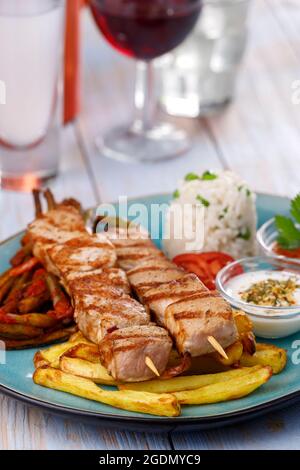 spiedini di souvlaki greci con patatine fritte Foto Stock