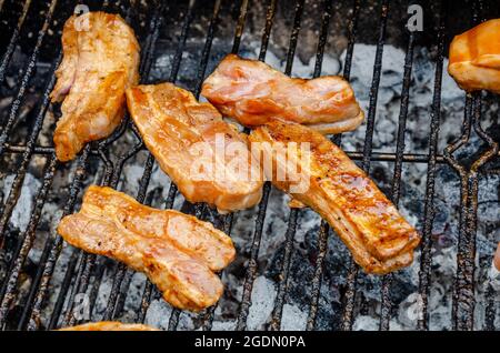 Pancia di maiale cucina su un barbecue su carbone di carboni. Foto Stock