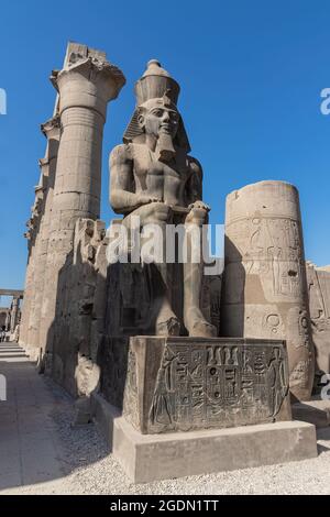 La gigantesca statua di Ramesse II nel Tempio di Luxor, Egitto, un antico e grande tempio egizio complesso situato sulla riva est del fiume Nilo in città Foto Stock